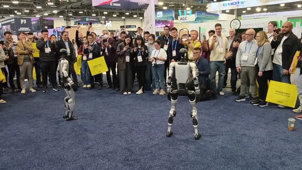 Unitree G1 humanoid robot at CES 2026 trade show drawing crowd of attendees to a brand booth activation