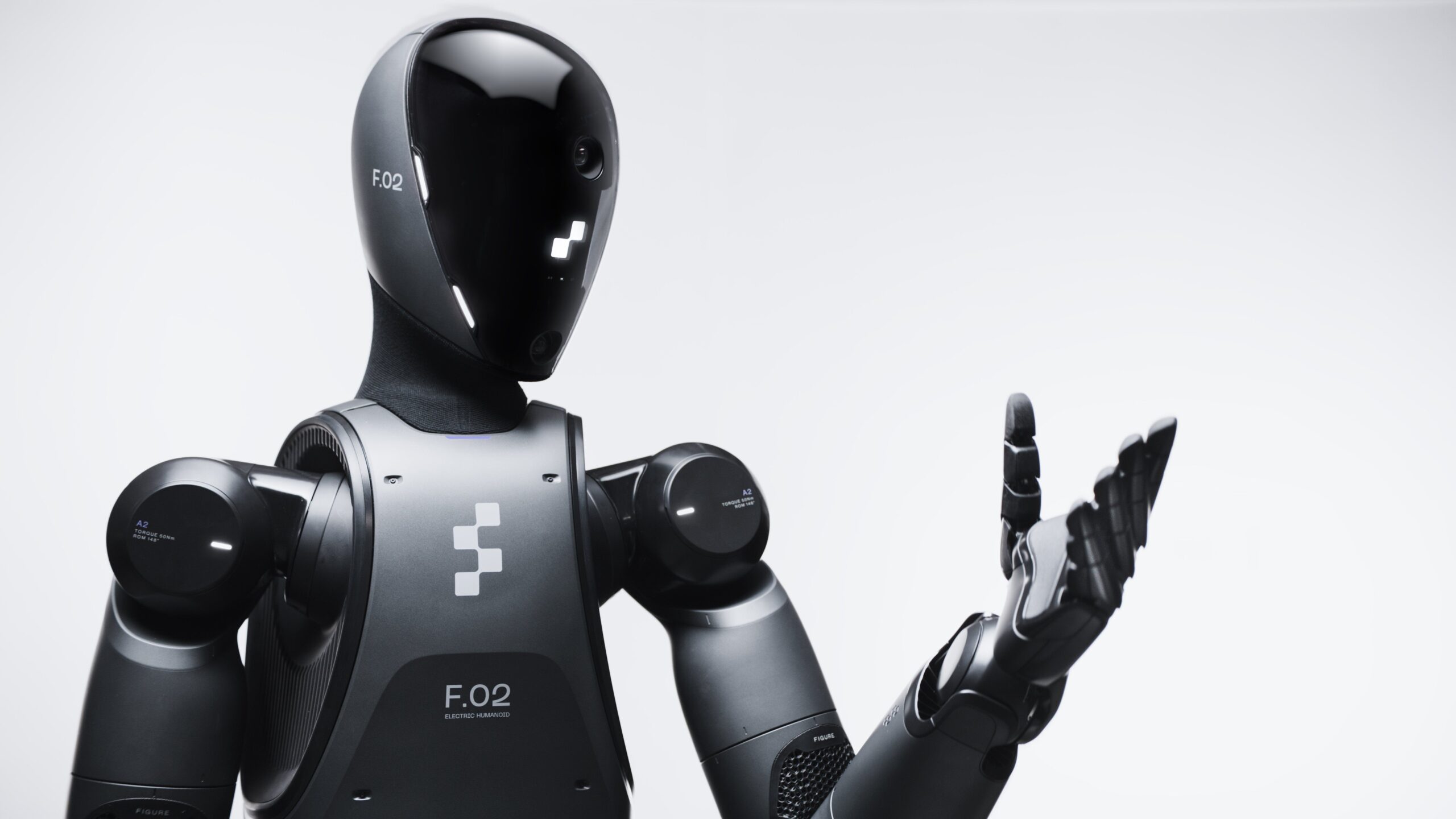 Figure 02 humanoid robot close-up with black casing and F.02 markings gesturing with open hand
