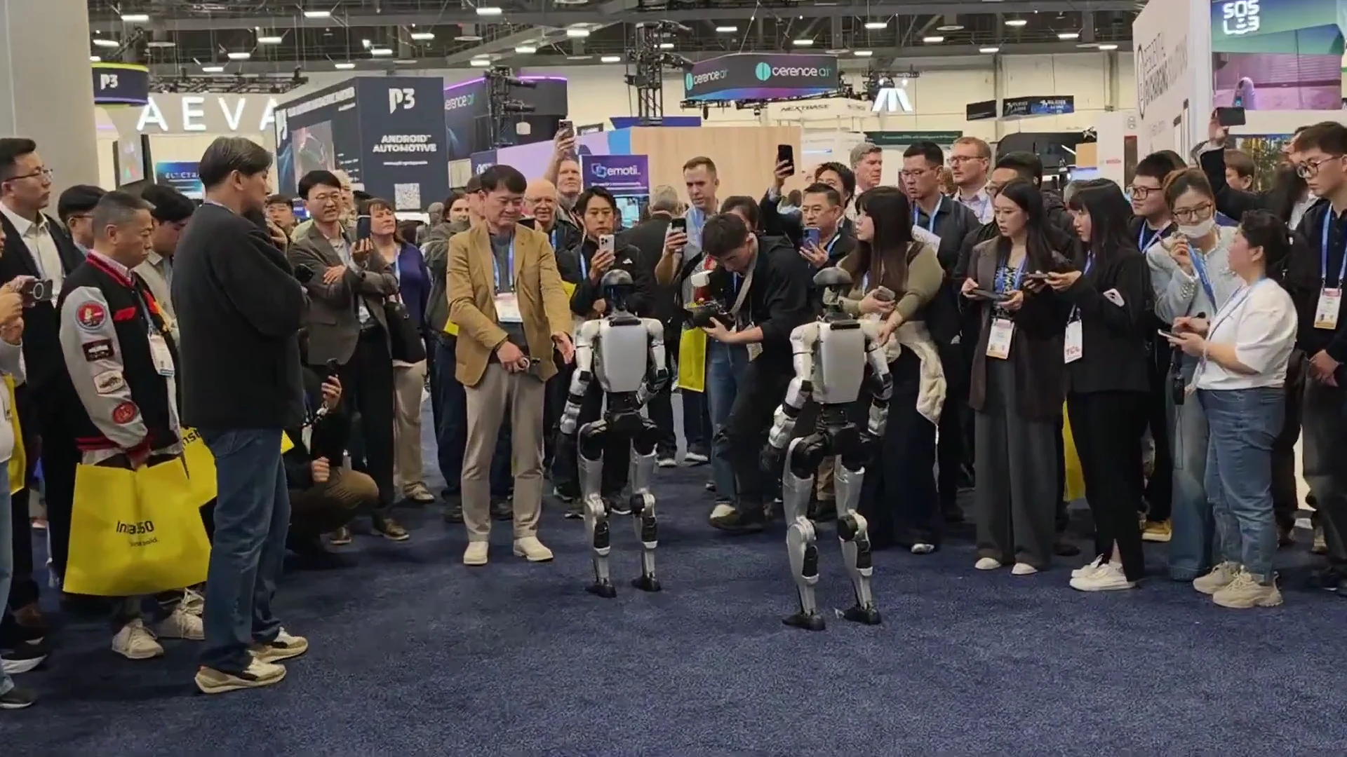 Close-up of two Unitree G1 humanoid robots running paired demo at CES 2026 exhibition booth
