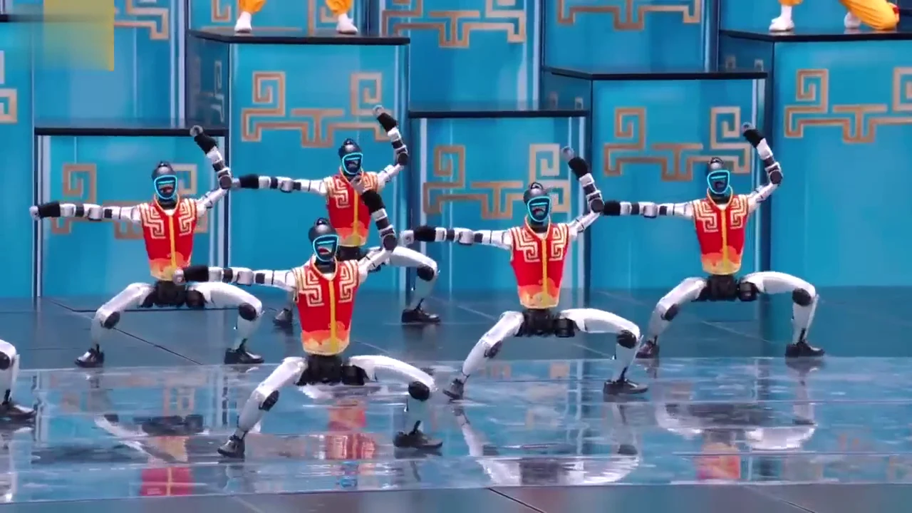 Four Unitree G1 humanoid robots on stage at an event, showing multi-robot scale and cost