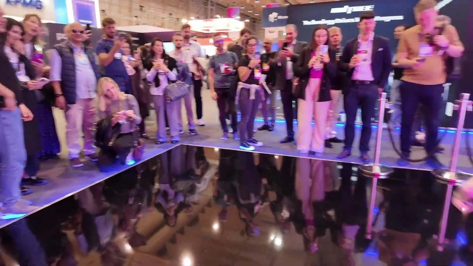 Unitree G1 humanoid robot engaging visitors in an indoor exhibit, demonstrating BrainCo Revo 2 hand capabilities