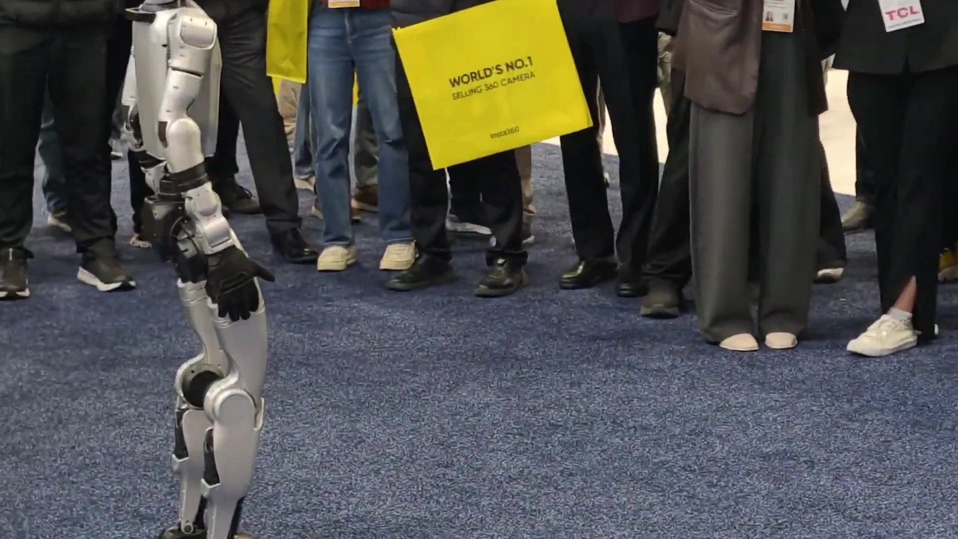 Unitree G1 robot drawing a crowd at CES trade show demonstrating movement to attendees at a live exhibition
