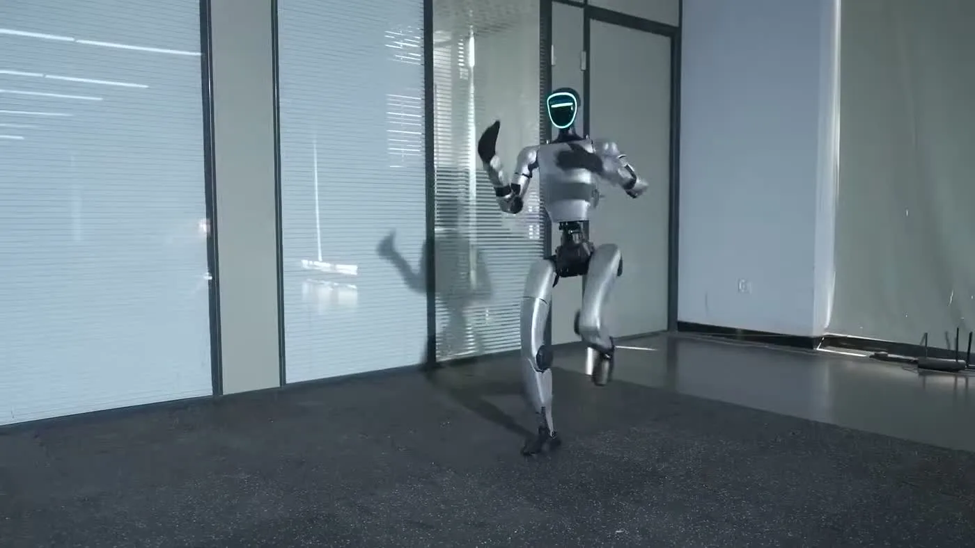 Unitree G1 humanoid robot in dynamic motion inside a glass-walled office space during a live event demonstration
