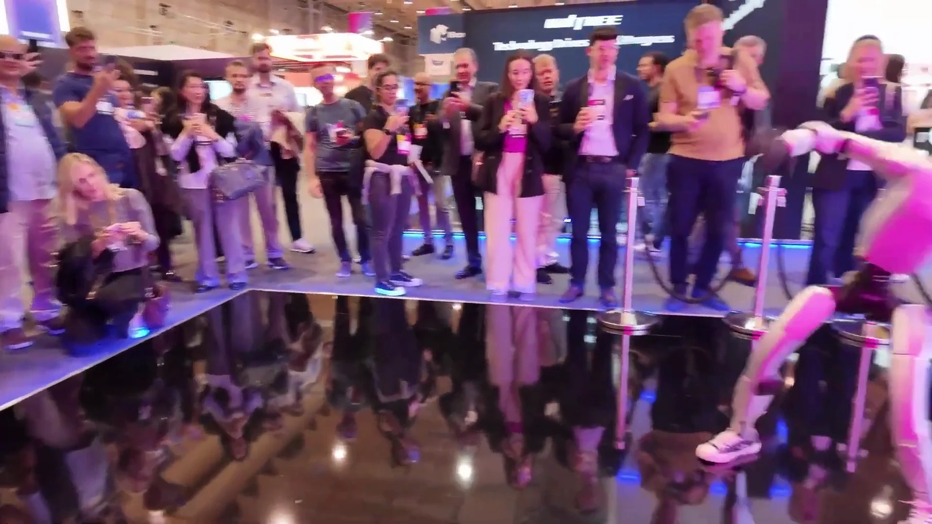 Audience at a tech expo surrounding a Unitree G1 robot, showing public engagement for European event deployments