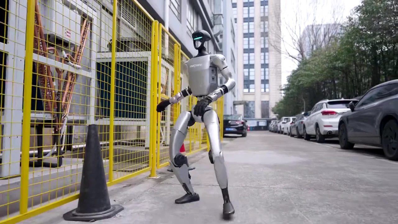 Unitree G1 humanoid robot walking outdoors on a city street showing its mobility and balance on real-world surfaces