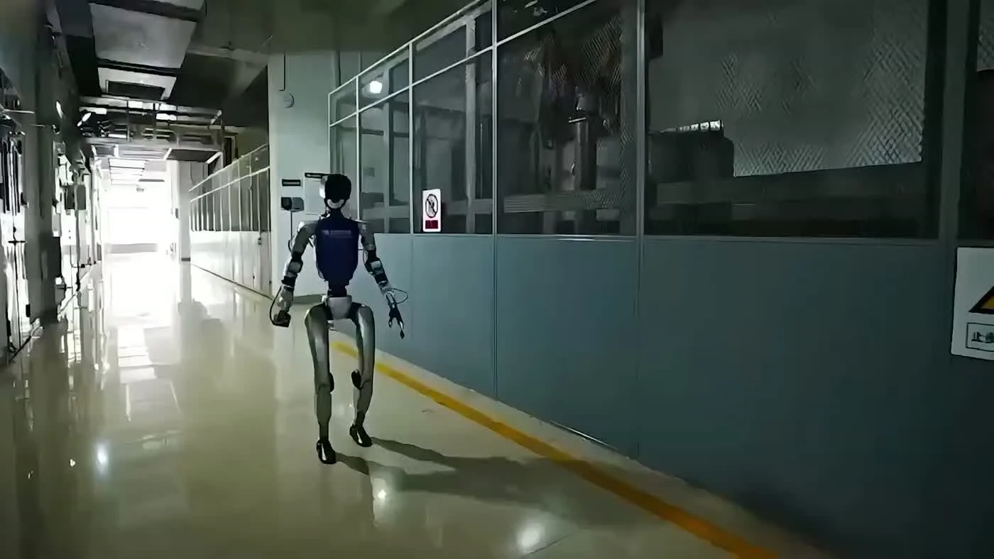 Unitree G1 humanoid robot walking through an indoor corridor showing its smooth movement at trade show events