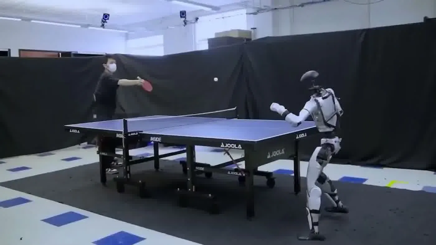 Humanoid robot playing table tennis with a human opponent showing interactive engagement that drives organic social content