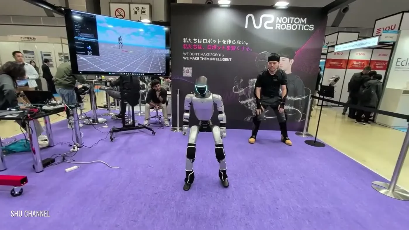 Unitree G1 humanoid robot at a Noitom Robotics booth with a motion-capture operator at a tech expo